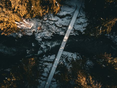Stunning aerial shot of a snow-covered bridge in Whistler's forest during winter.
