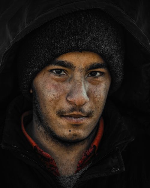 Free Close-up portrait of a young Middle Eastern male with strong expression, wearing a winter hat. Stock Photo