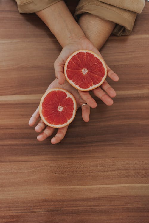 Irisan Grapefruit Di Tangan