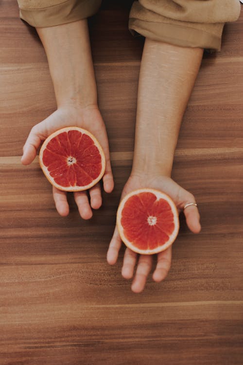 Round Sliced Fruit On Person's Hand