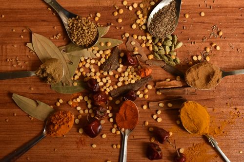 Free A vibrant display of various Indian spices arranged creatively on a wooden table. Stock Photo