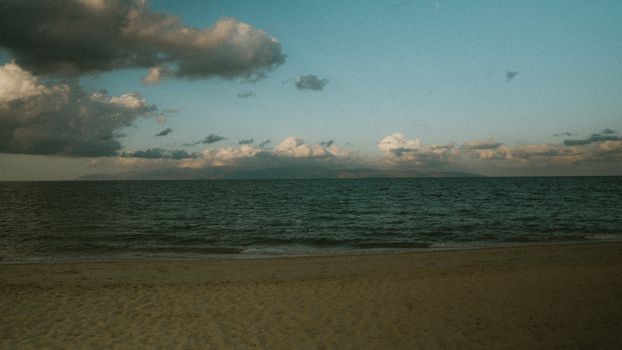 Peaceful Baja California beach with calm sea and clouds at sunset.
