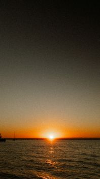 Capture the serene view of a Baja California sunset with golden hues over the tranquil sea.