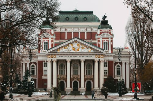 Free Snowy winter scene of Ivan Vazov National Theatre in Sofia, showcasing Baroque architecture. Stock Photo