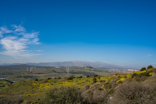 Free Scenic view of wind turbines and Mount Hermon in the Golan Heights with clear skies. Stock Photo