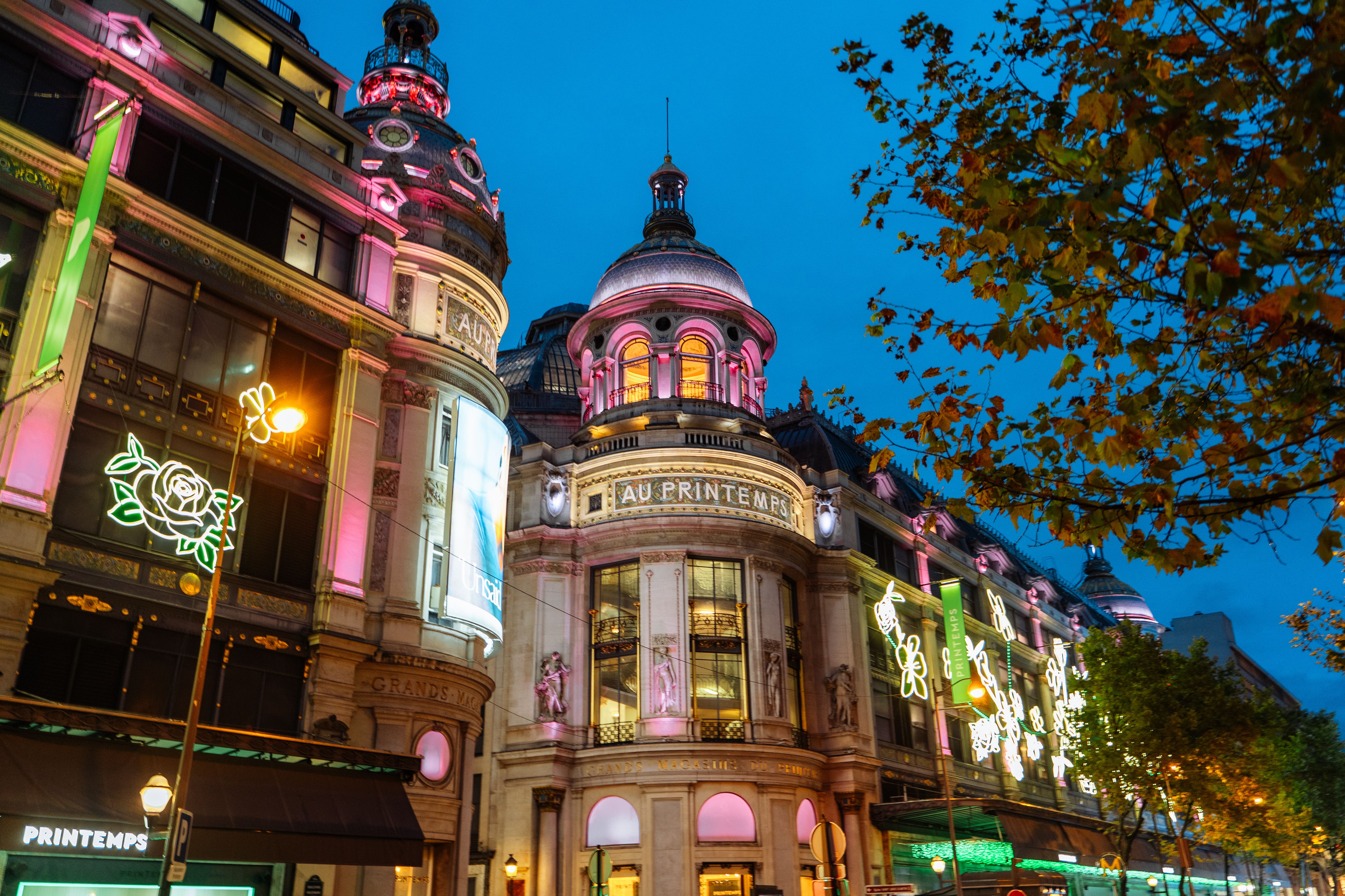 Illuminated Haussmann architecture in Paris at night, glowing with vibrant lights.