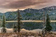 宁静的山湖与松林倒映着美国犹他州白雪皑皑的山峰