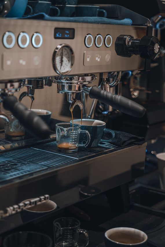 Espresso machine brewing fresh coffee into small cups