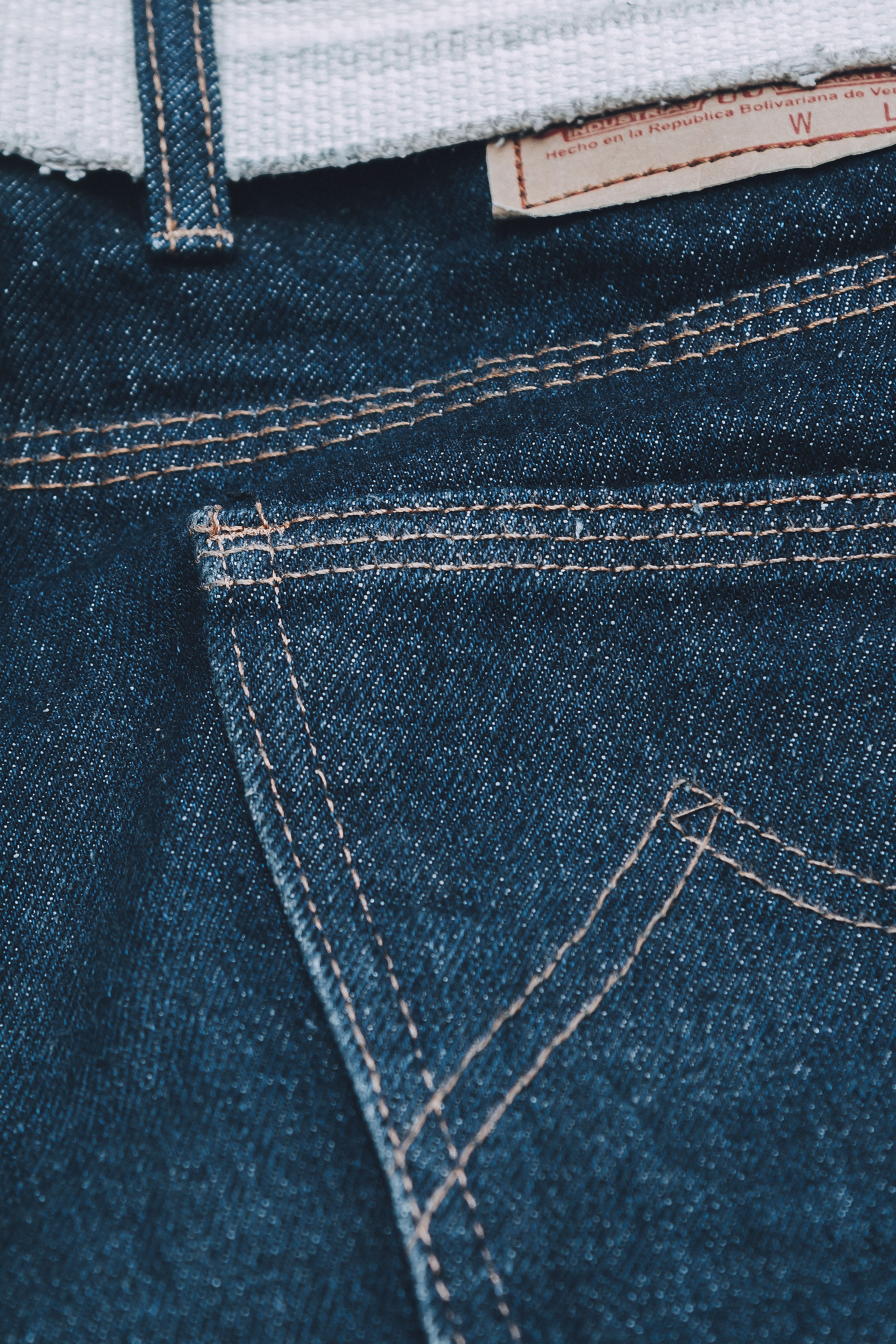 Detailed macro shot of denim jeans fabric showing precise stitching and texture.