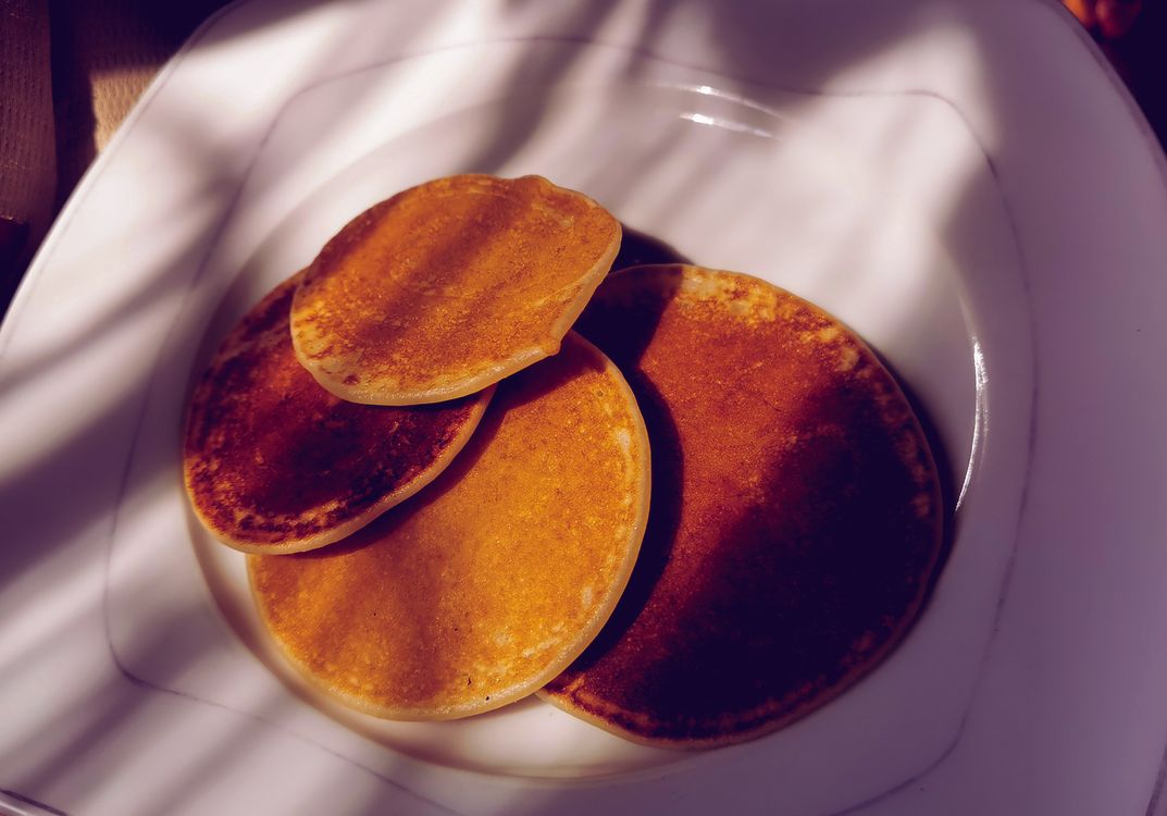 Golden brown pancakes on a white plate, showcasing the crispy homemade finish that rice paper scallion pancakes achieve