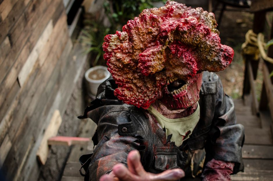 A detailed zombie cosplay costume depicting horror elements in an outdoor setting.