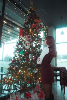 A decorated Christmas tree indoors with colorful lights and ornaments, creating a warm festive atmosphere.