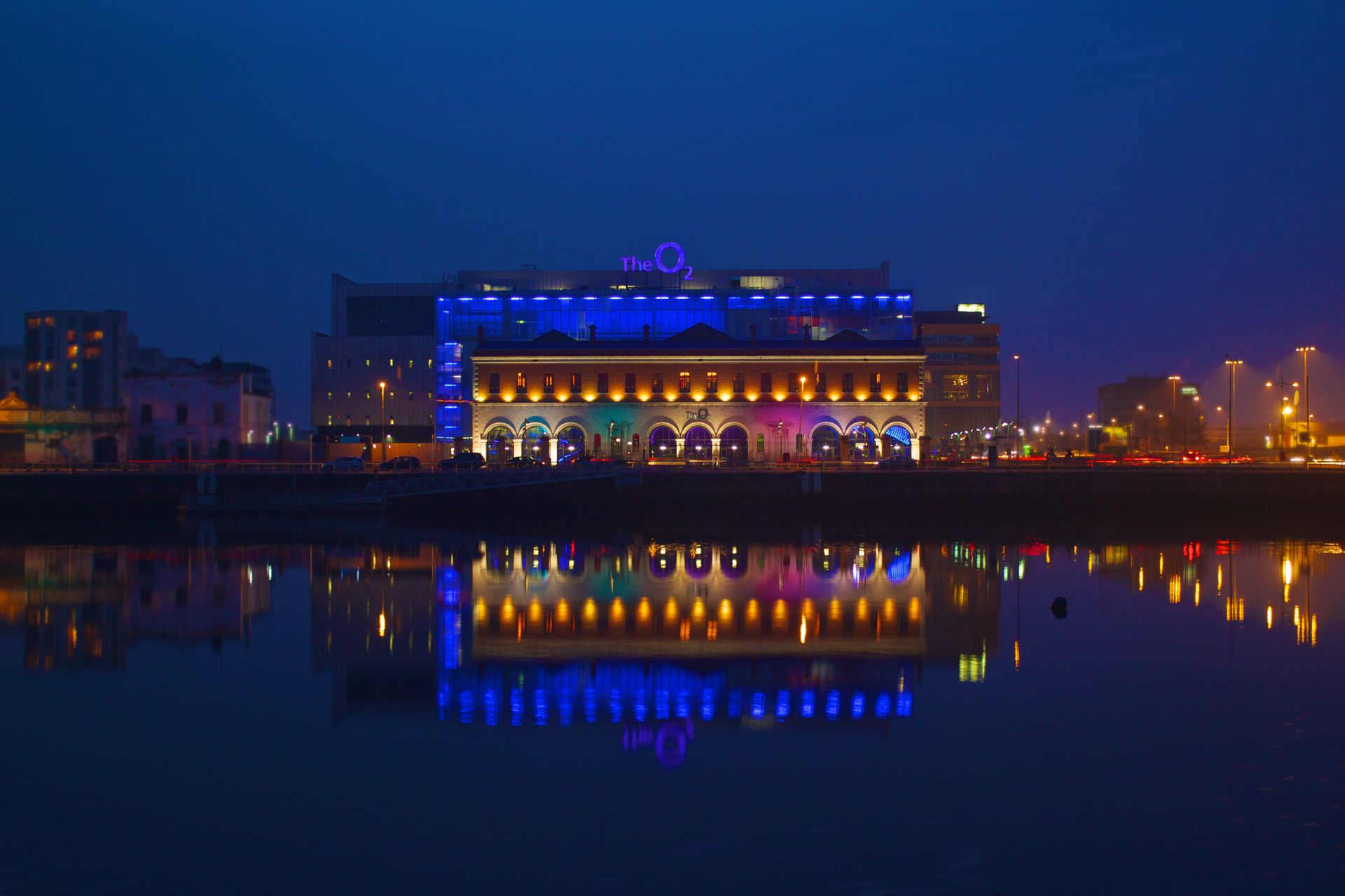 Colorful night view of The O2 in Dublin with vivid reflections in the water.