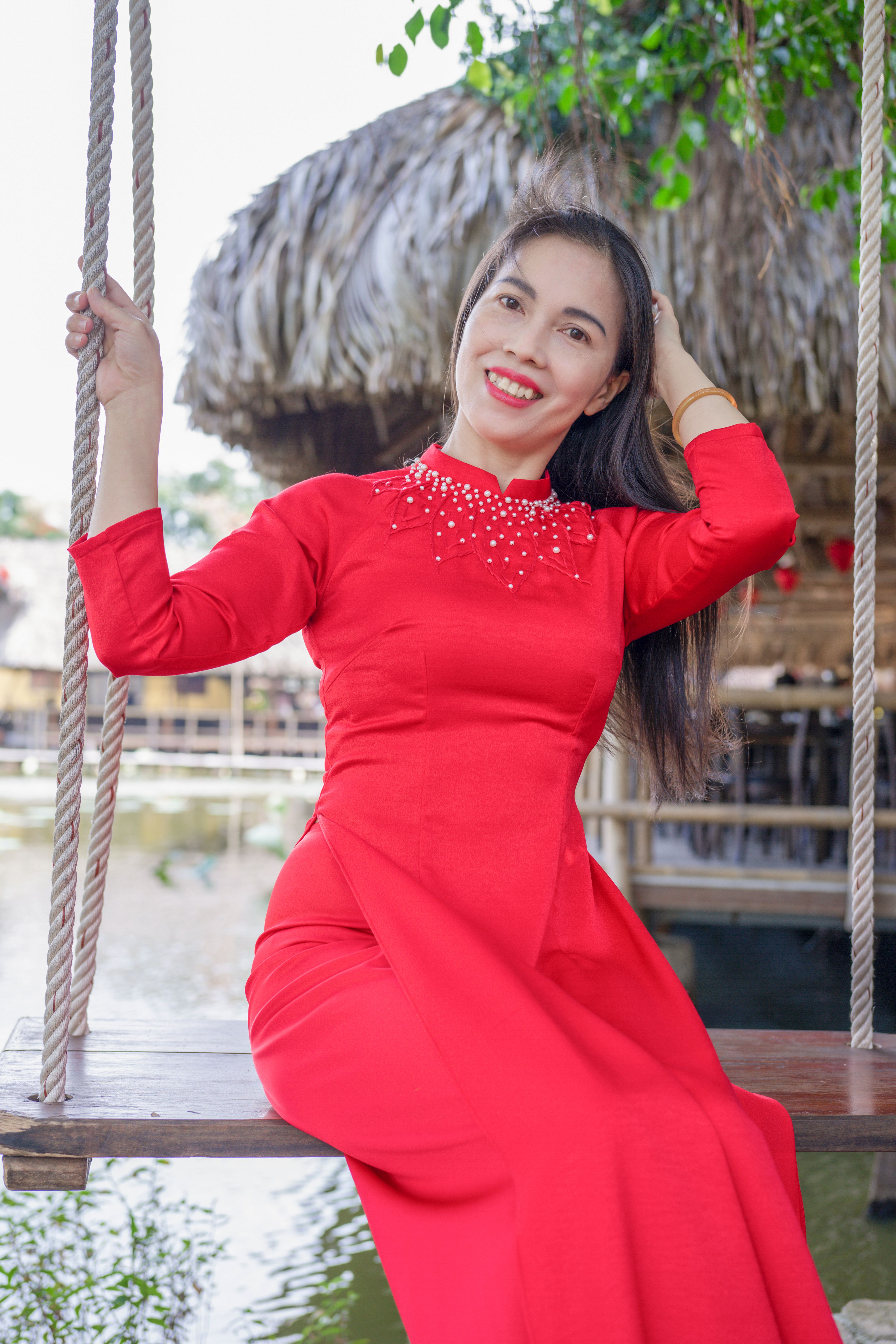 Woman in Red Traditional Dress Smiling Outdoors · Free Stock Photo