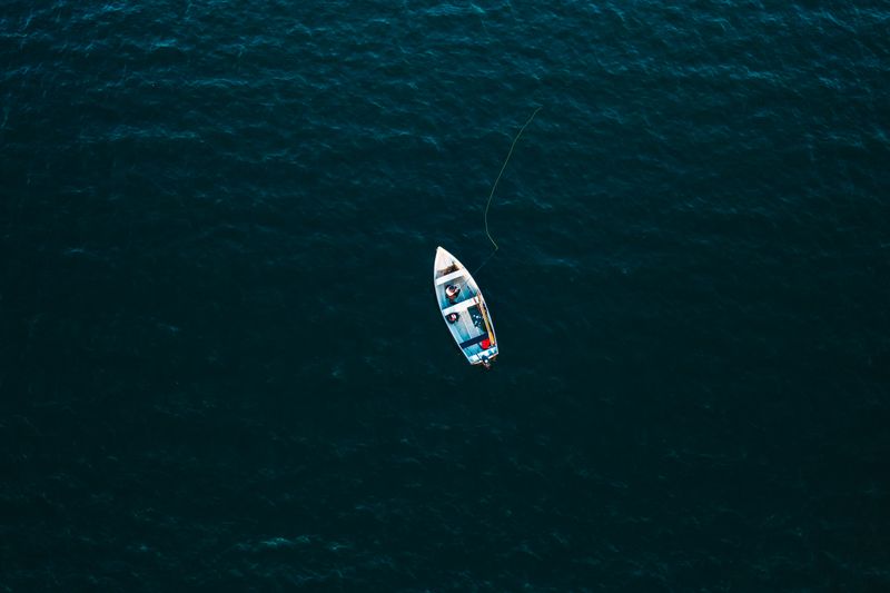 Top-down aerial view of a motor yacht underway on the ocean