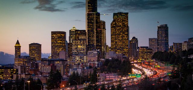 A stunning twilight view of Seattle's skyline with illuminated skyscrapers and busy traffic below.
