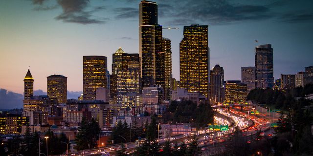 A stunning twilight view of Seattle's skyline with illuminated skyscrapers and busy traffic below.