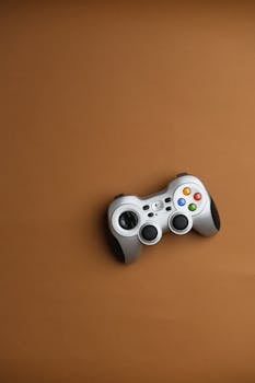 Wireless gaming controller on a brown background, showcasing digital entertainment and technology.