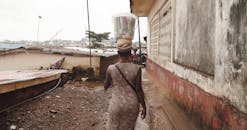 城市街道繁华，一个女人头顶集装箱的后视图