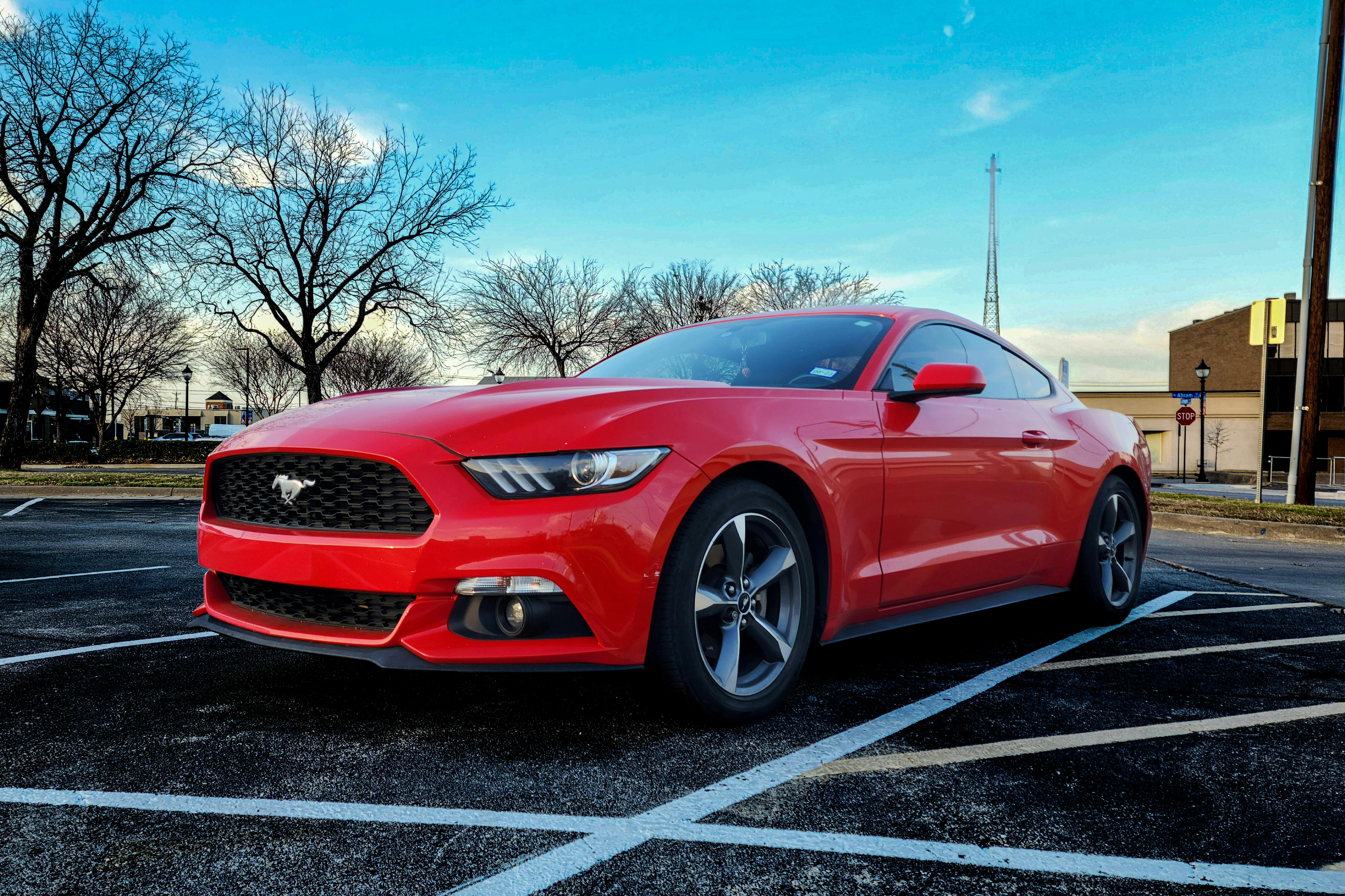 Vibrant red Ford Mustang GT parked on a clear day in Arlington, Texas.