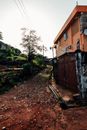 乡村街景中，橙色建筑与污垢路径相映成趣