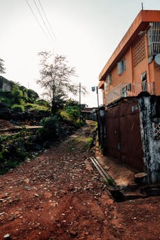 乡村街景中，橙色建筑与污垢路径相映成趣