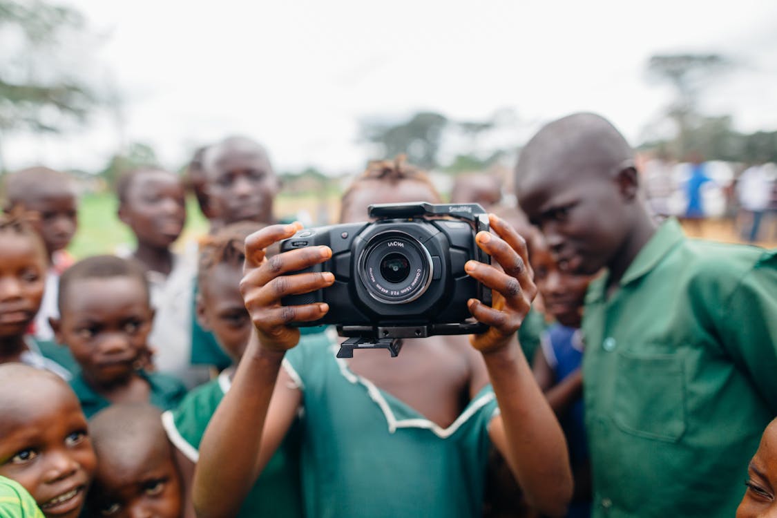 Children Standing and One Person Holding Camera