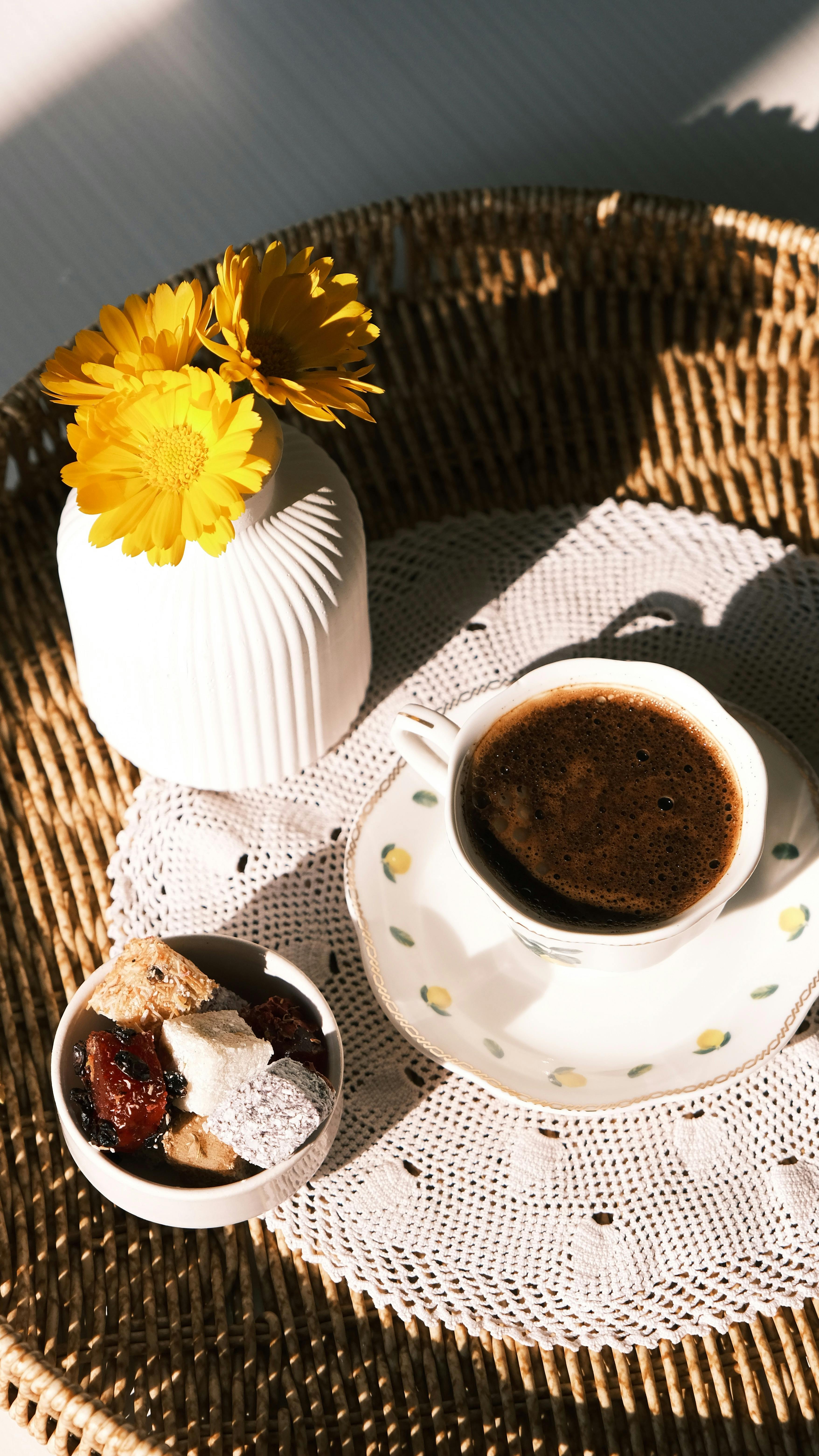 A beautiful morning coffee with flowers and sweets on a wicker tray.