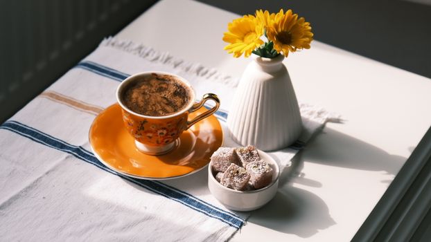 Aesthetic coffee setup with flowers on a sunlit table, perfect for mornings.