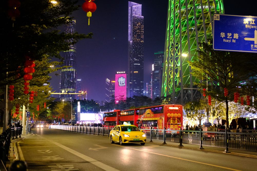 Guangzhou street at night with taxis, red lanterns and the Canton Tower