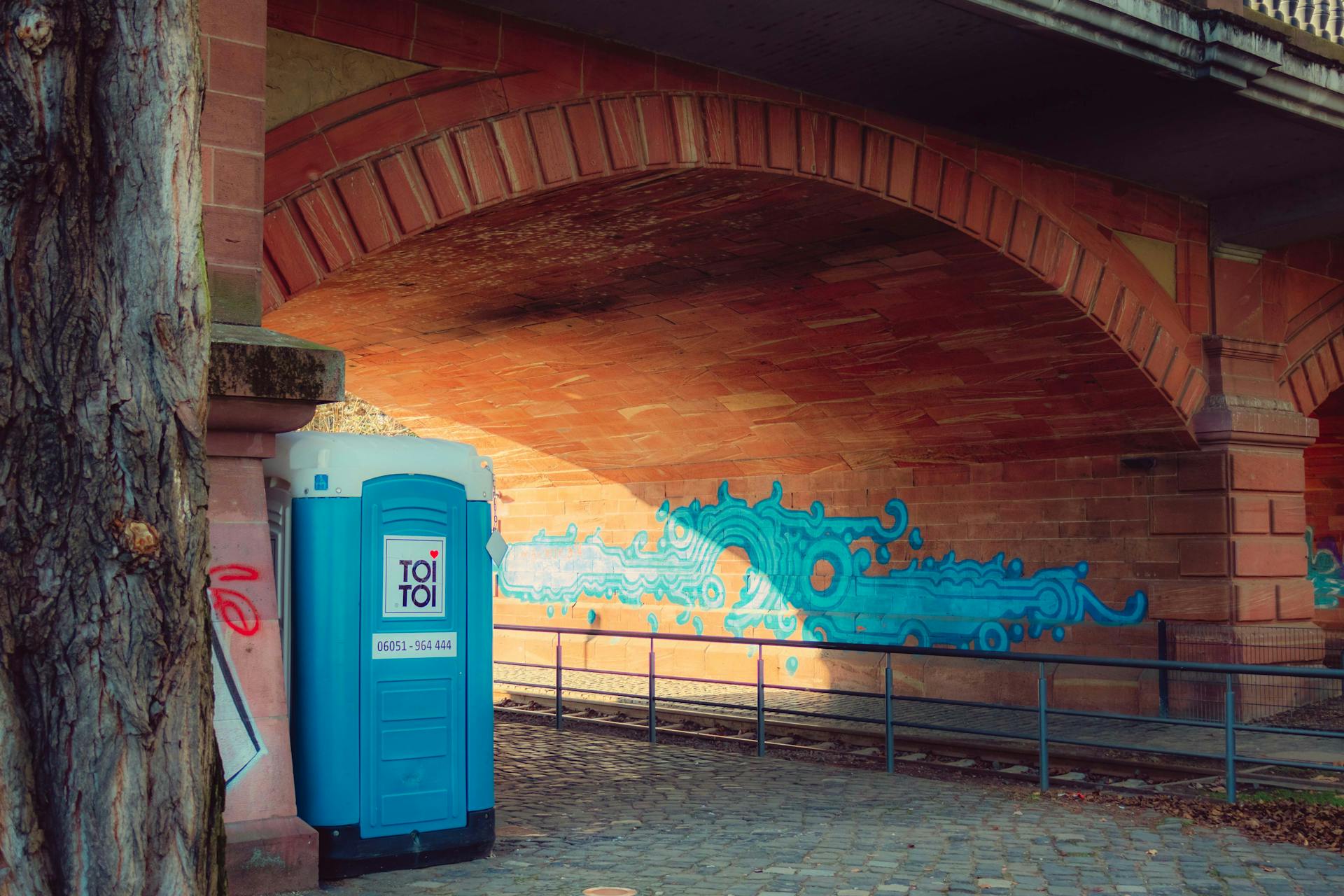 Underpass in Frankfurt with graffiti and a portable toilet.