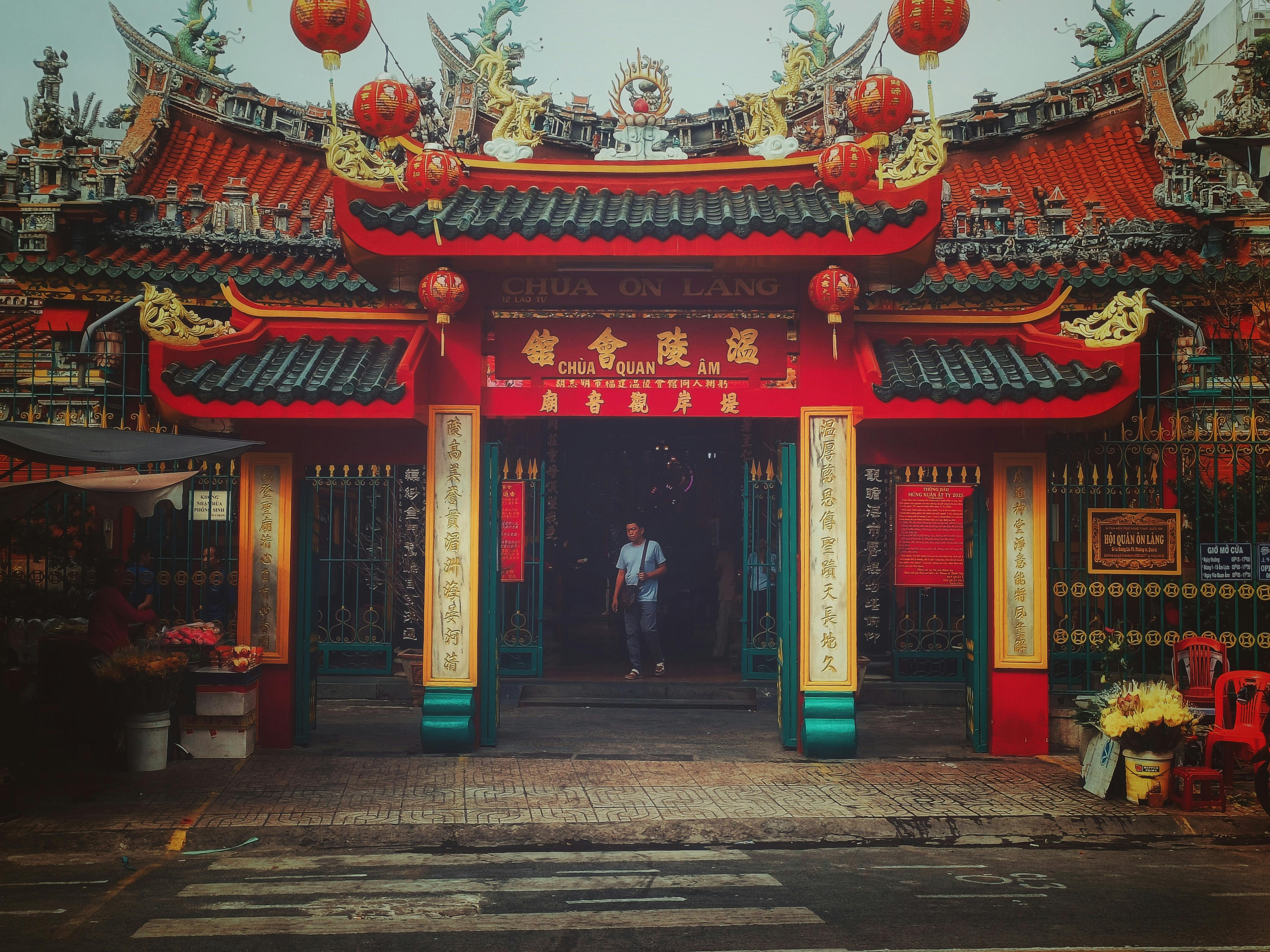Front view of Chua Quan Am Temple adorned with red lanterns and Chinese decorations.