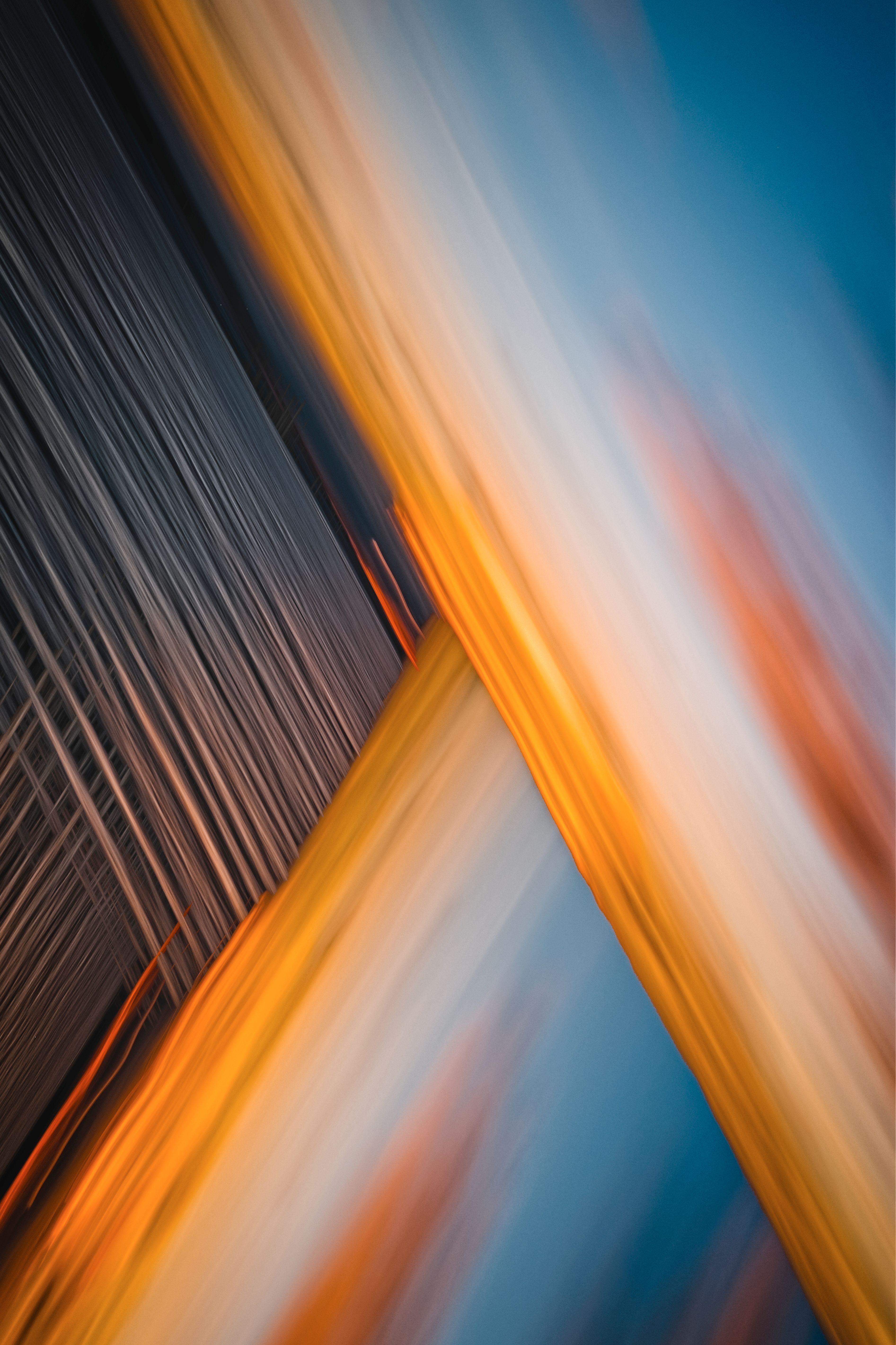 Abstract image featuring dynamic lines in warm golden hues against a blue background.