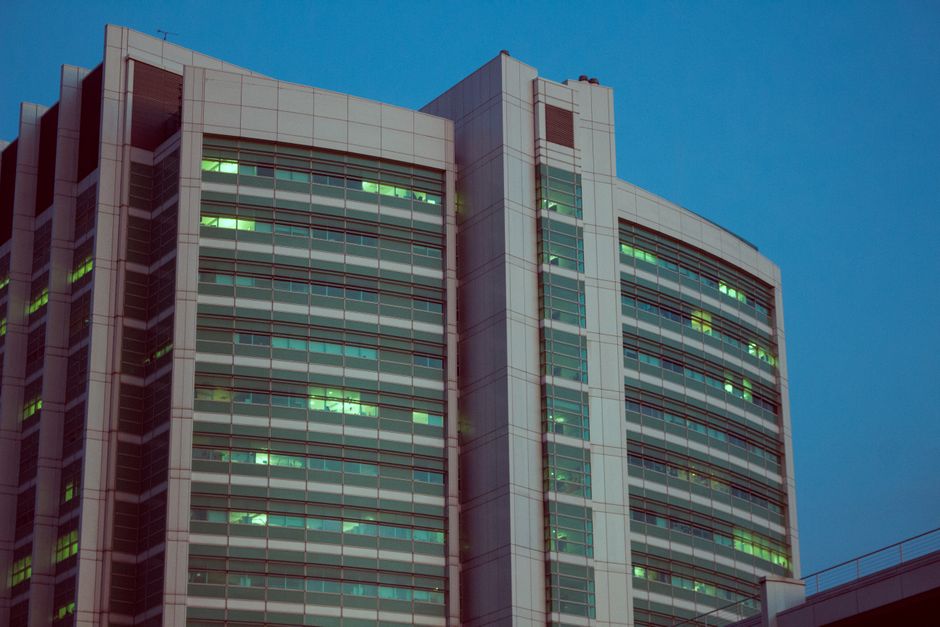 Split view comparing a pre-leased occupied office tower and a vacant commercial shell space for sale in Gurgaon with city skyline backdrop