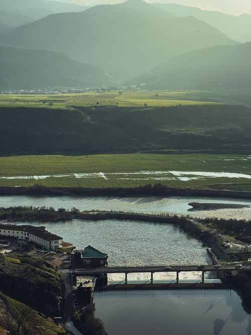 Free A beautiful Albanian mountain landscape with a serene river, bridge and fields. Stock Photo