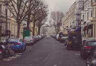 伦敦的经典街景中，汽车和摩托车停放在优雅的建筑之间