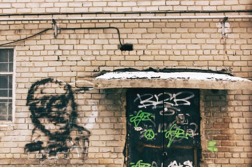 Free Street art on a brick wall with urban graffiti and snow-covered surfaces. Stock Photo