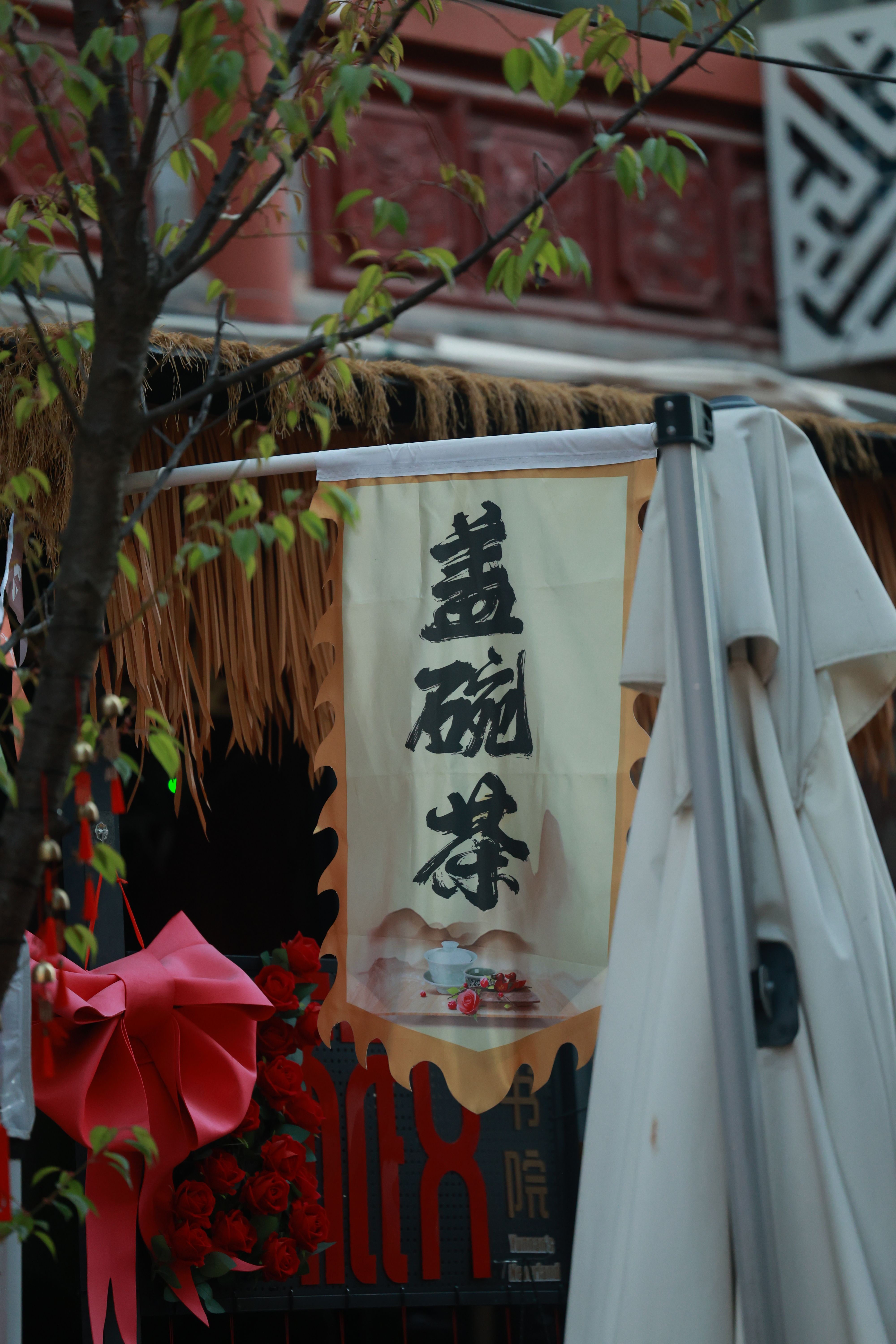 Tea shop sign in an Asian market with traditional decor and red accents.