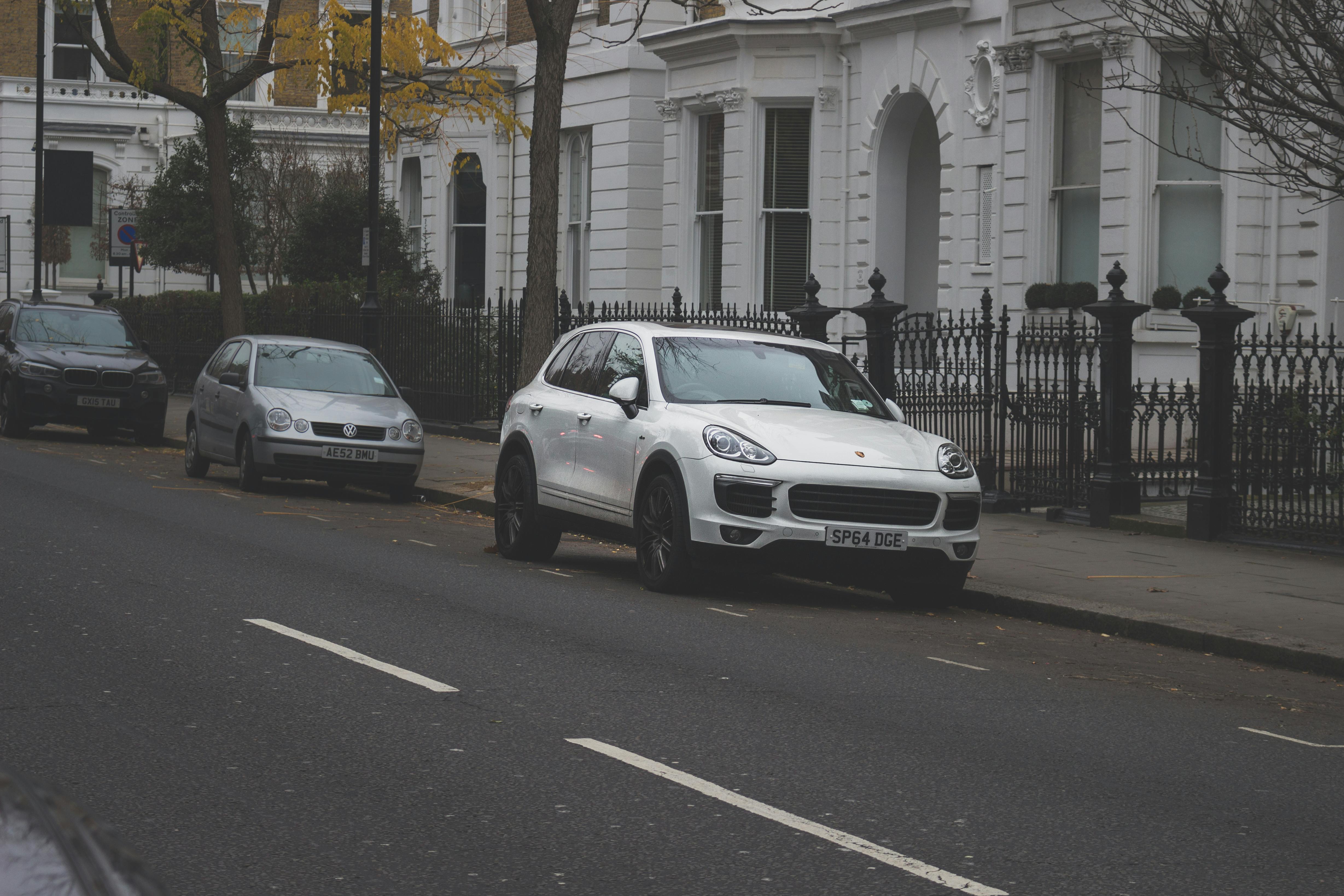 several cars parked on road near building