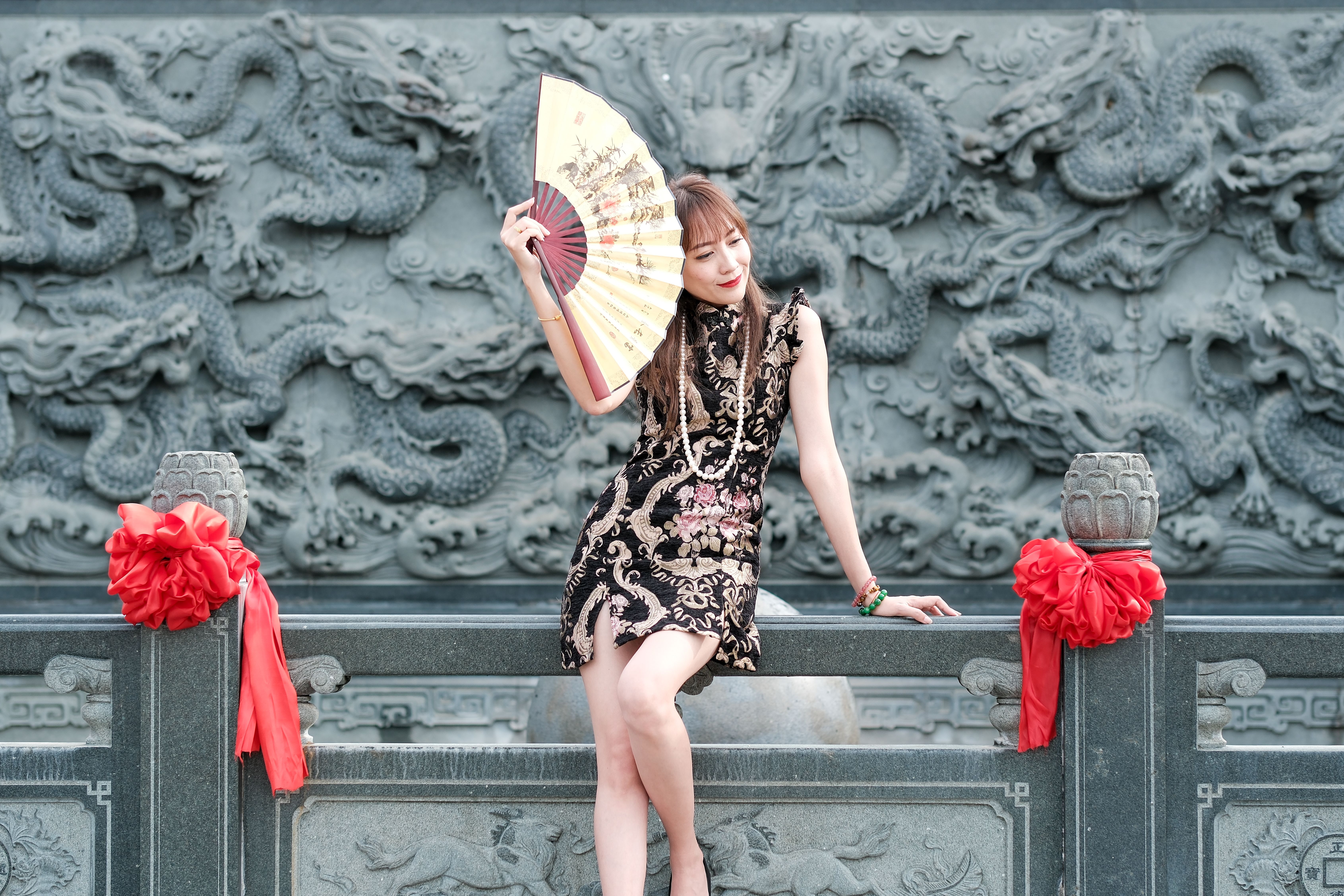 Elegant Woman with Fan in Traditional Setting · Free Stock Photo