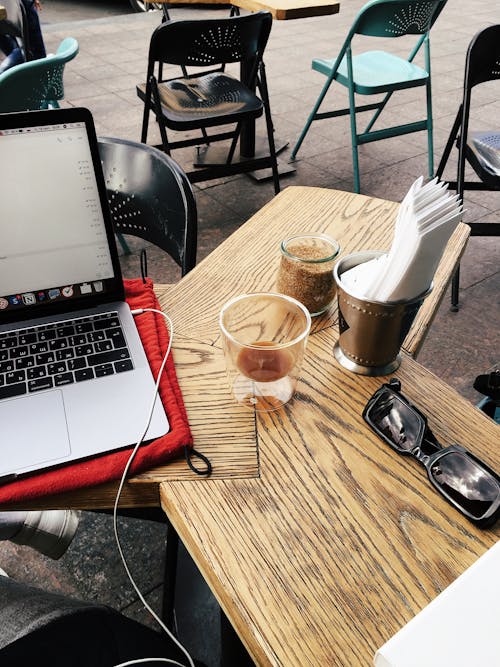 Laptop on cafe table near freelancer