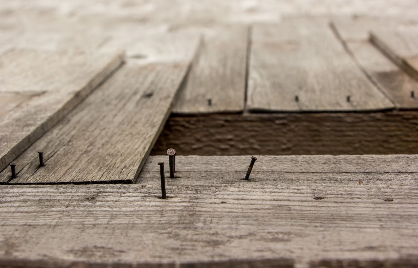 Detailed view of weathered wooden boards and nails, showcasing rustic texture.