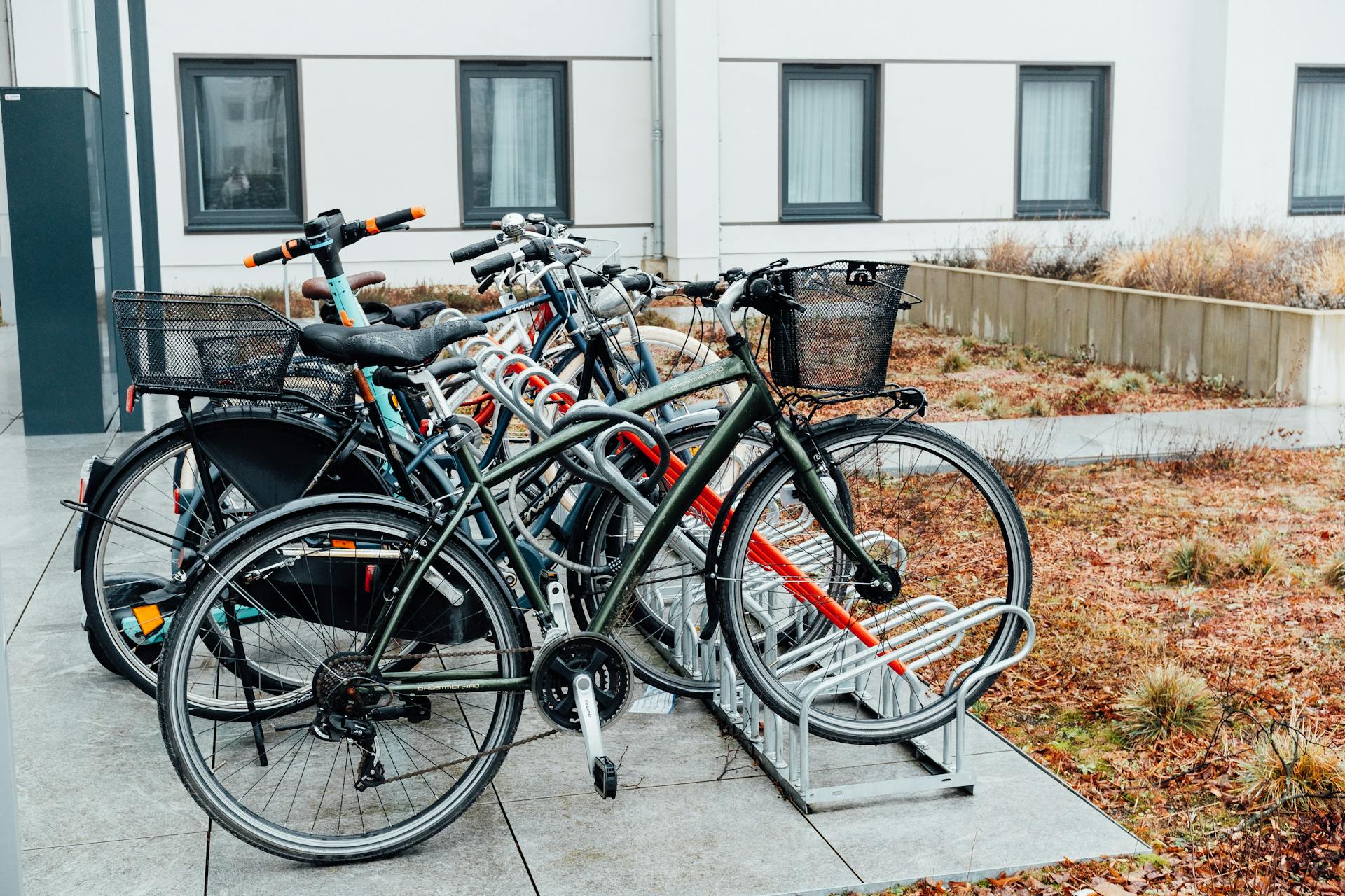 Array of bicycles parked in an urban bike rack outdoors, showcasing a sustainable transport option.