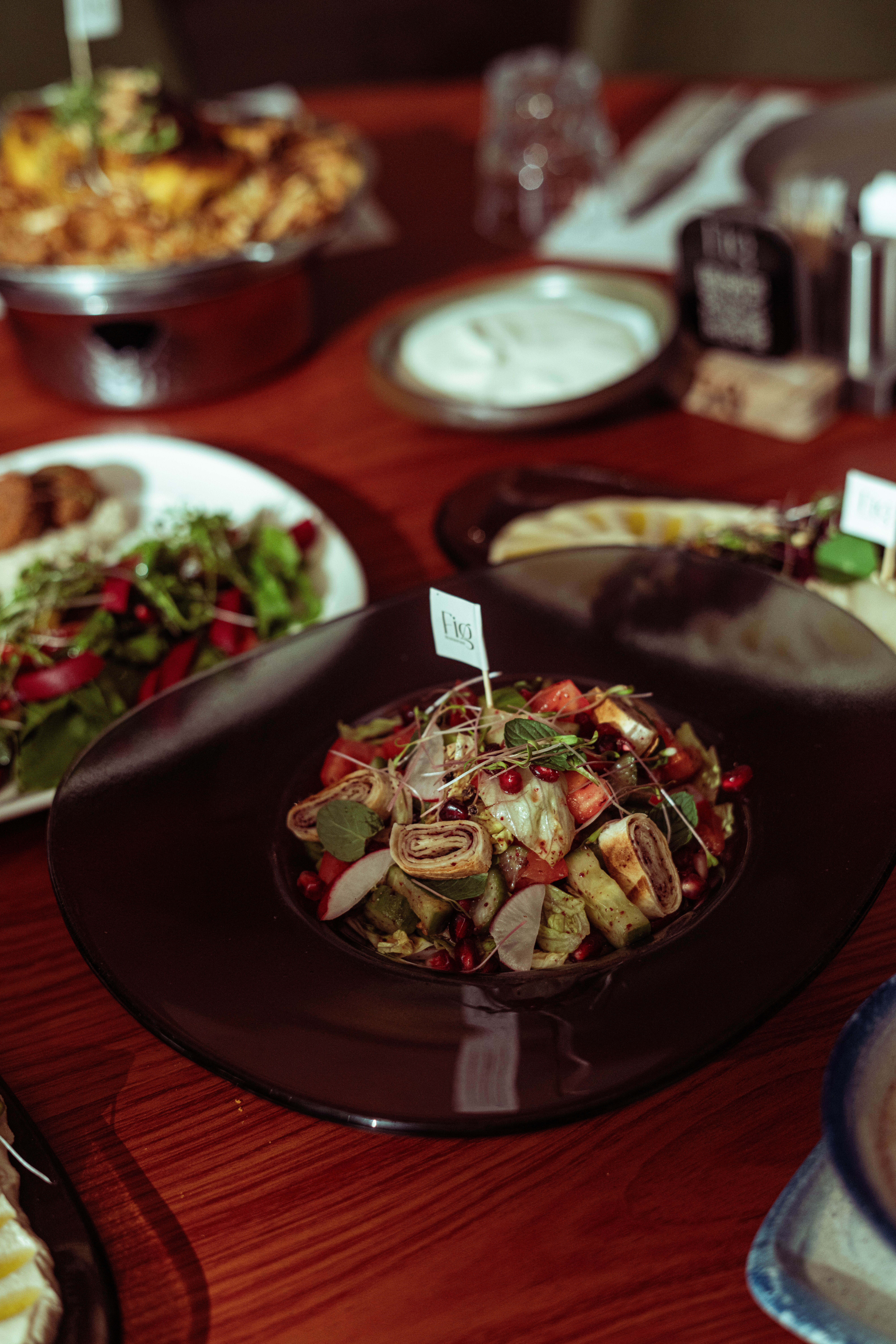 A beautifully arranged table setting featuring fresh Middle Eastern dishes including salad and various appetizers.