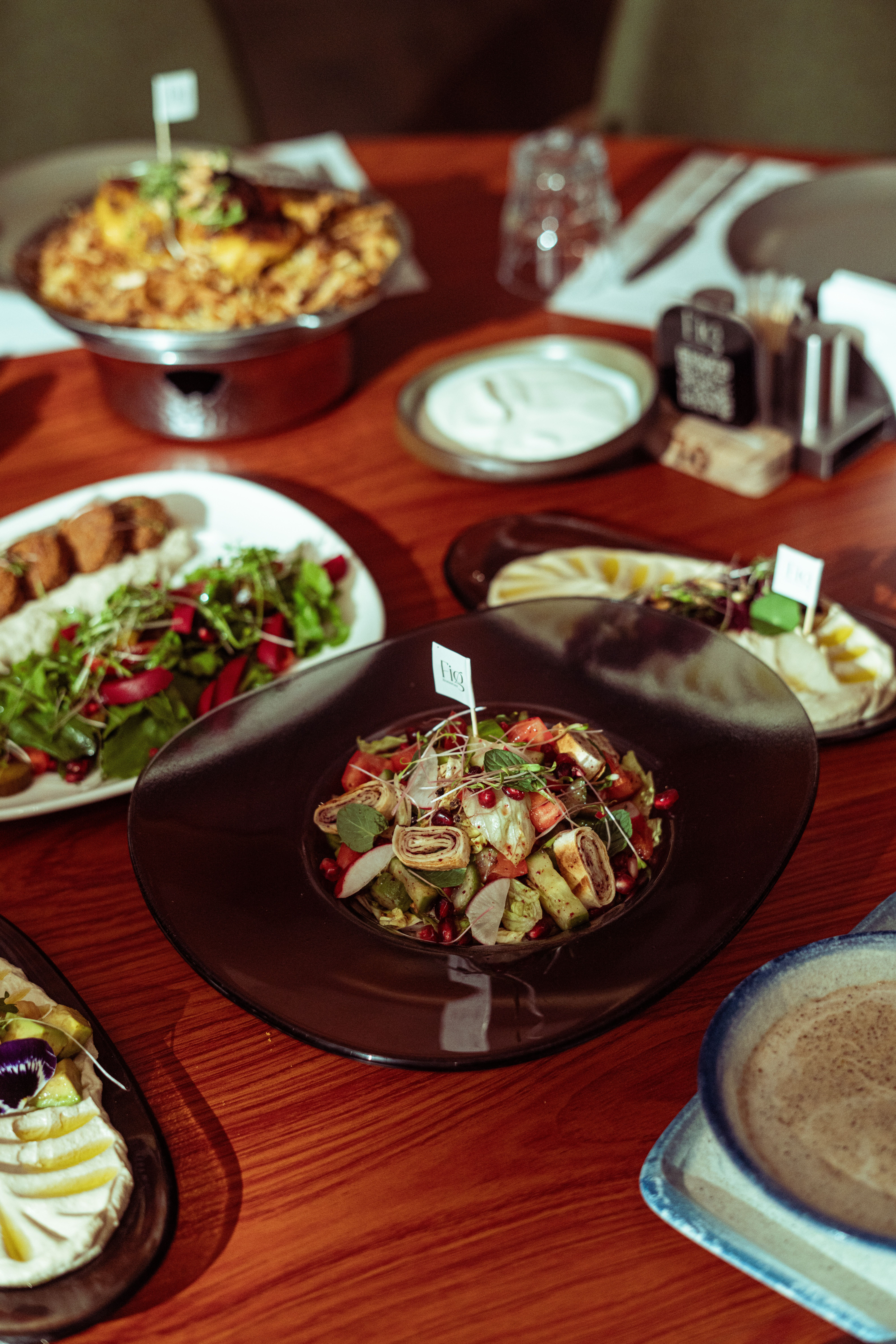 A flavorful display of Middle Eastern dishes arranged on a rustic wooden table in Baghdad.