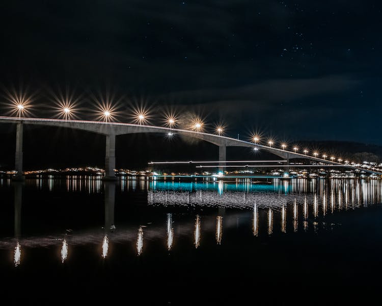 Illuminated Bridge Over River At Night