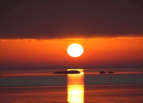 Breathtaking sunrise seen at Cove Island Park in Stamford, Connecticut, creating an orange reflection on the calm sea.