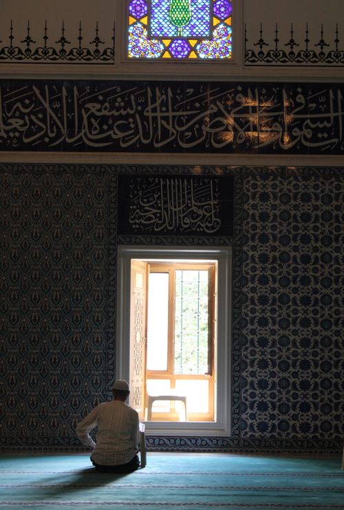 Free Man sitting in a mosque, engaging in a peaceful moment of prayer and reflection. Stock Photo
