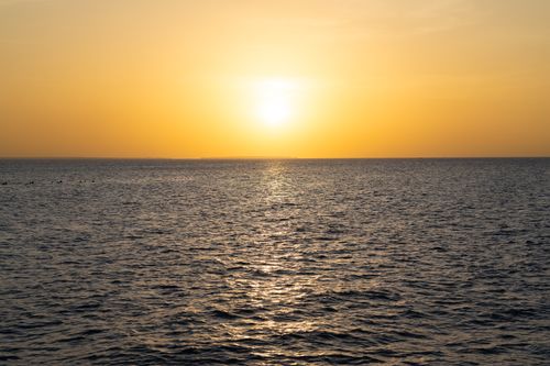 Free Spectacular sunset over the Indian Ocean in Zanzibar with calm waves and golden glow. Stock Photo