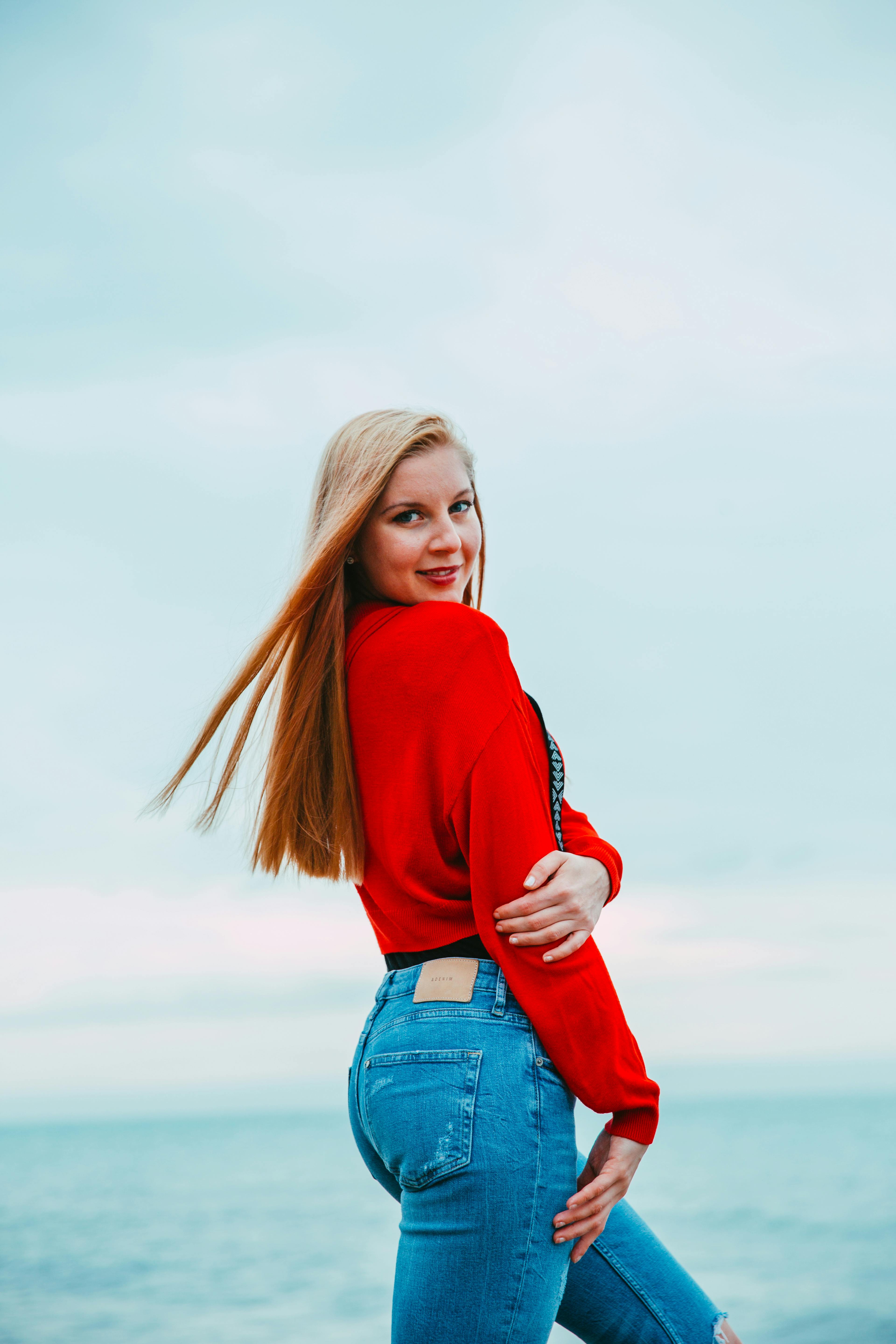 Woman Wearing Red Long-sleeved Shirt and Jeans Pants · Free Stock Photo